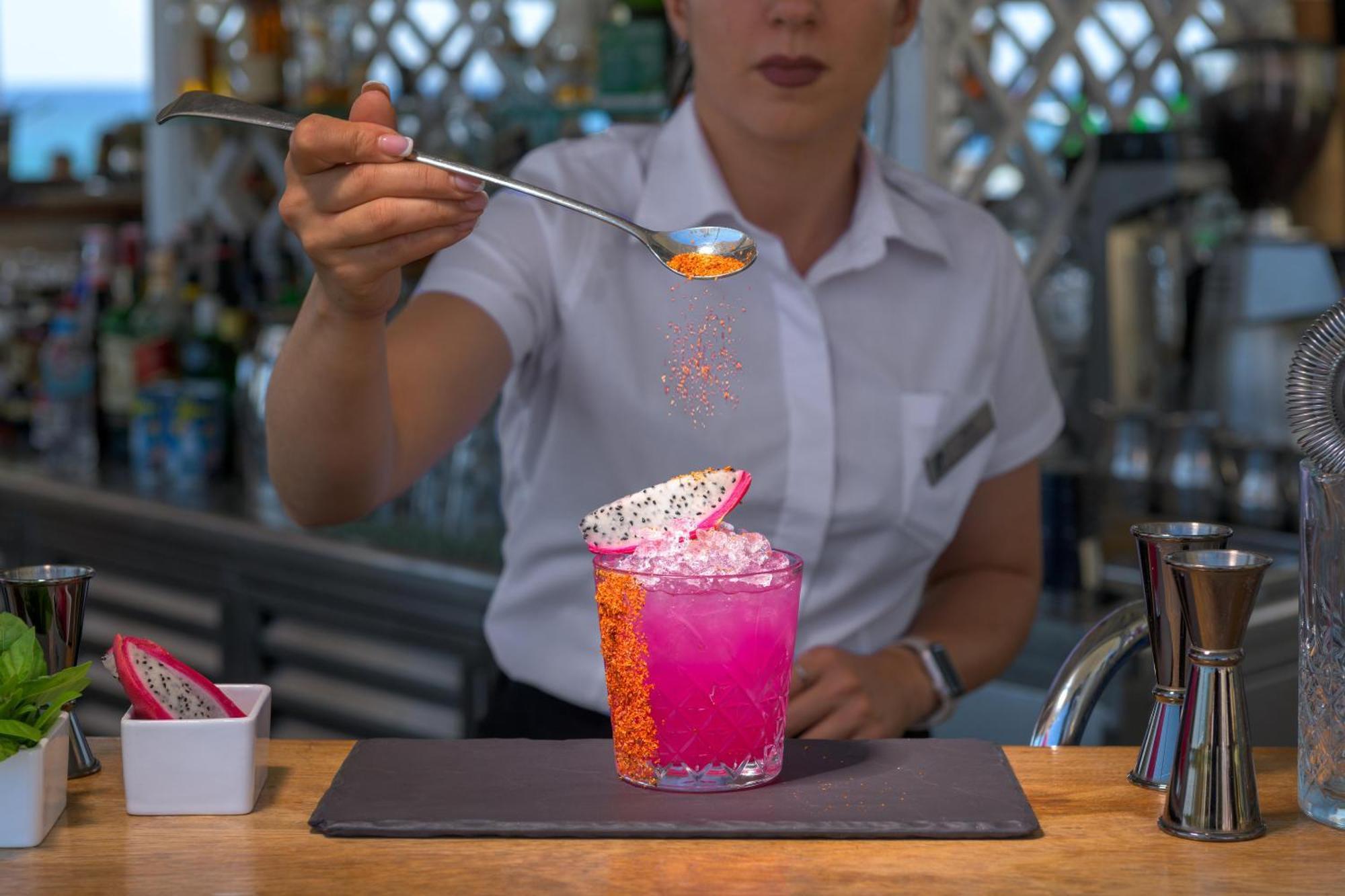 Rodos Palladium Leisure & Wellness Mourátagas Exterior photo A bartender adding a garnish to a cocktail